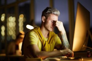 Man at computer experiencing tension headache